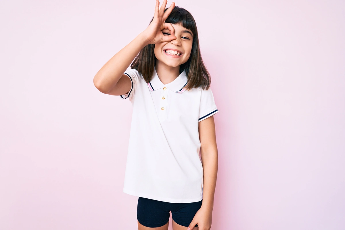 A little girl grinning while showing off her teeth